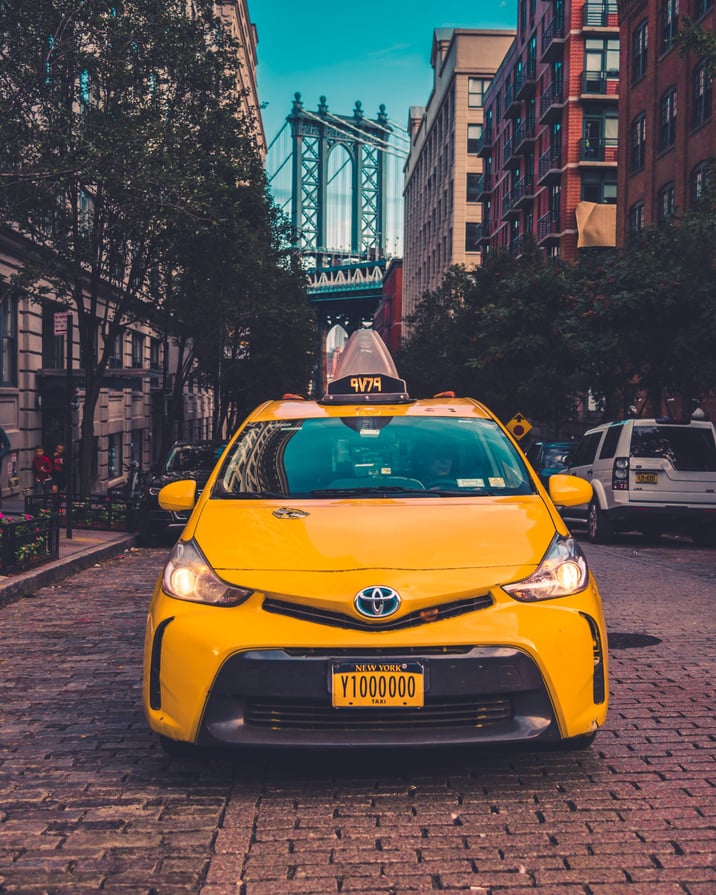 Modern taxi car on tiled pavement in city